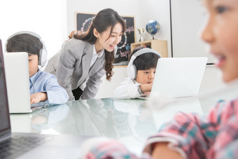 老师辅导学生使用电脑<strong>兴趣班</strong>小学生场景