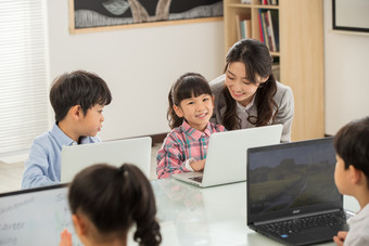 老师辅导学生用电脑幼儿园健康生活方式摄影图