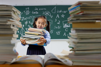 搬着沉重课本的小学女生小学生照片