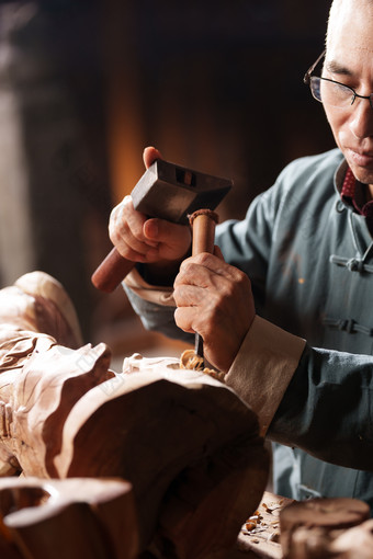 工匠师认真雕刻刀子传统服装艺术品摄影图