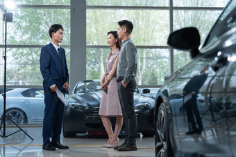 汽车销售人员和青年<strong>夫妇握手</strong>现代摄影图