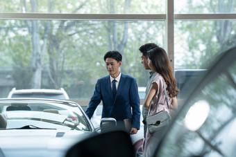 <strong>汽车</strong>销售4S店销售协助青年女人摄影