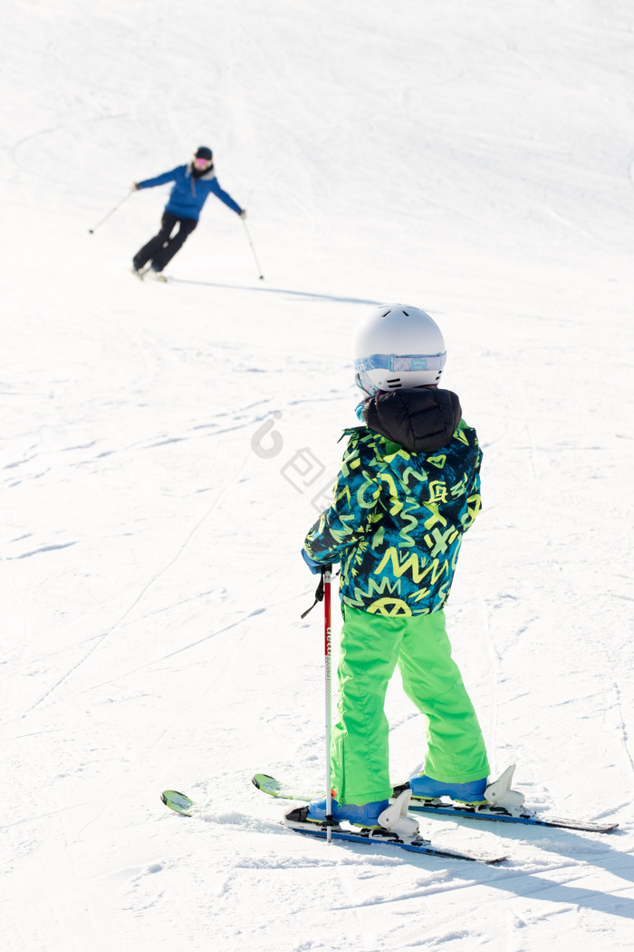 竖版拍摄滑雪儿童凝望滑雪的人图片