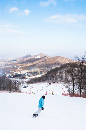 竖版拍摄在雪道上滑雪的运动员