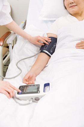 护士帮老年患者测量血压