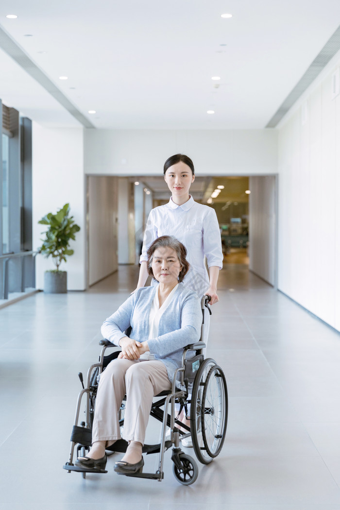护士推着做轮椅的女性患者图片