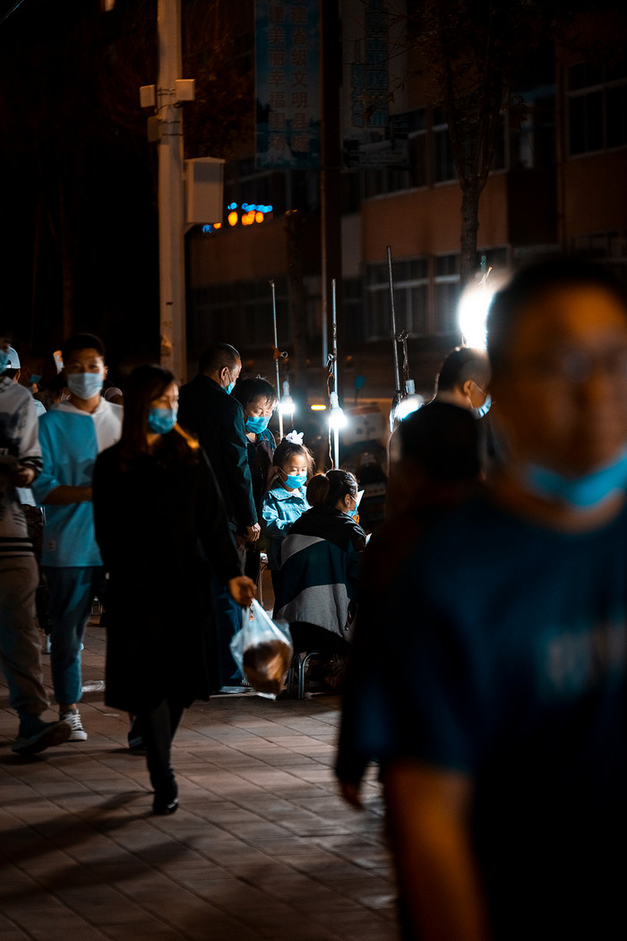 夜晚在夜市中行走的路人图片