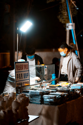 夜市晚间在贴膜摊位等待的路人