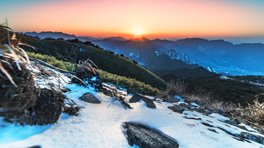 群山间冰雪覆盖的山峰日出