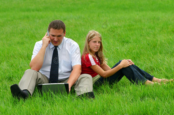 坐在草地上的男人和女孩