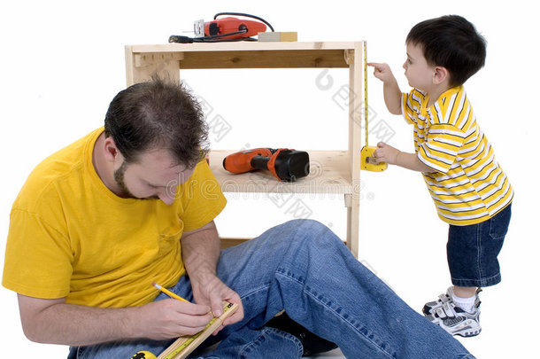 男孩和他父亲一起建了一个储藏柜