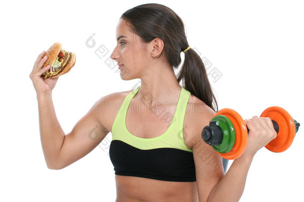 年轻漂亮的女孩举着五颜六色的重物和一个巨大的奶酪汉堡