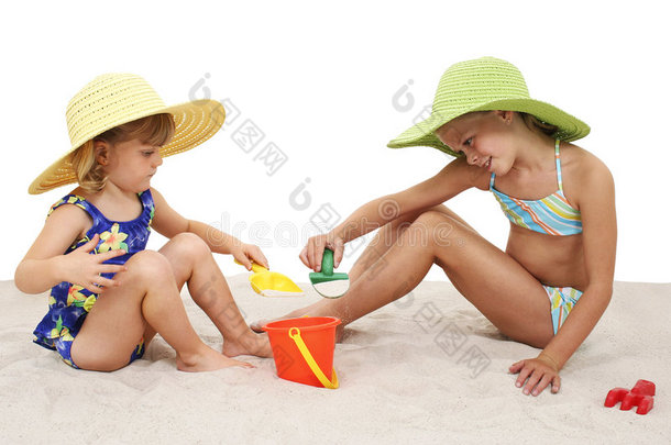 戴着沙滩帽在沙滩上玩耍的美丽姐妹