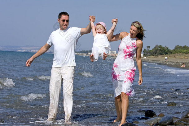 西班牙海滩上与女儿玩耍的年轻家庭
