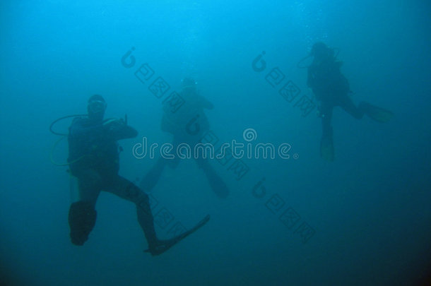 三名潜水员在深海潜水