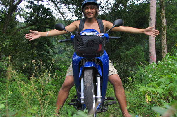 丛林中骑摩托车的亚洲男孩