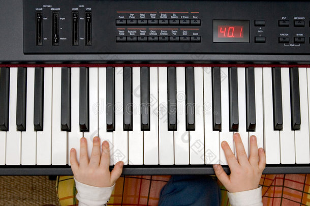 小男孩用手操作电子钢琴或键盘