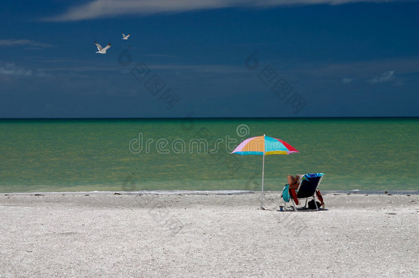 在沙滩伞下看书