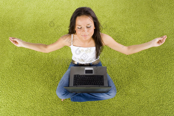 带着笔记本电脑的女人在<strong>绿地毯</strong>上放松
