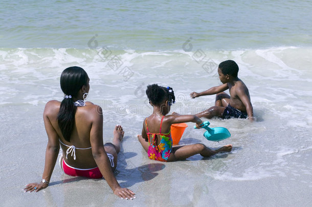 非洲裔美国妇女带着孩子在海滩上放松