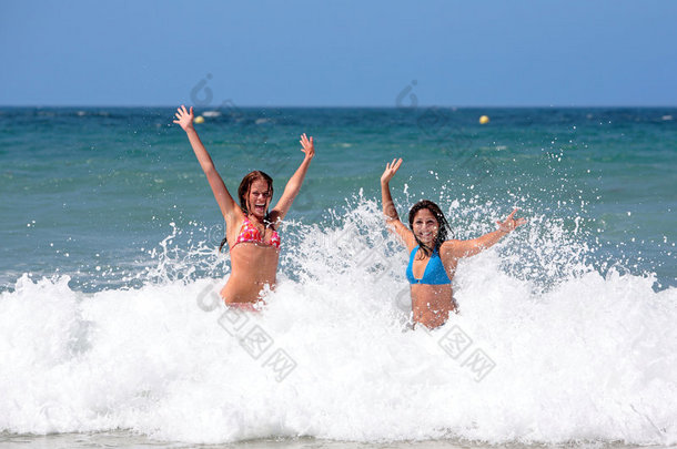 两个年轻漂亮的女朋友在海边度假