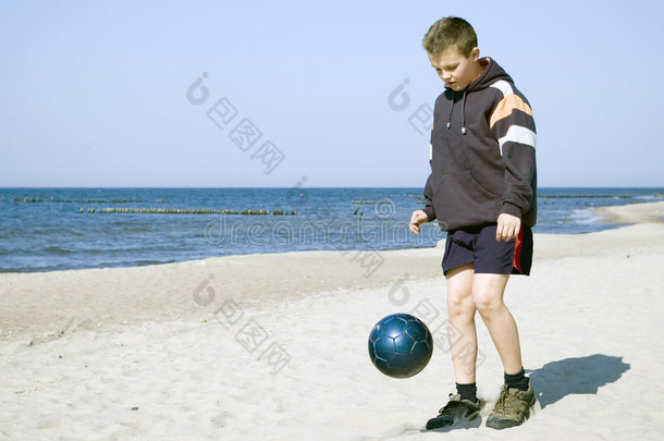 在沙滩上打球的男孩。