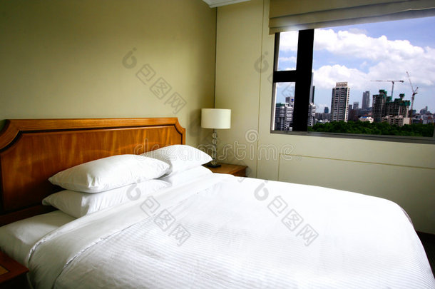 俯瞰城市景观的现代酒店卧室。