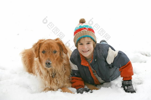 在雪地里和狗玩耍的男孩