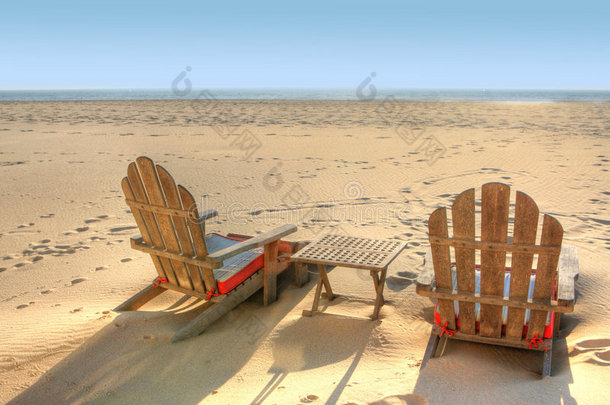 两张沙滩椅坐在沙滩上