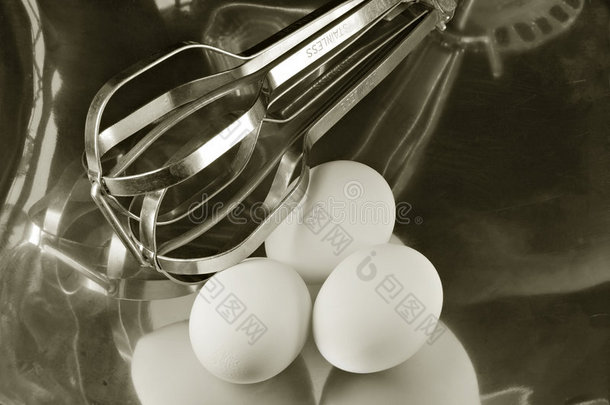 金属盘中的鸡蛋和搅拌器