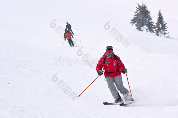 三个滑雪者从山上跑下来