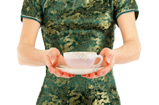 一位身着中式服装的妇女正在端茶