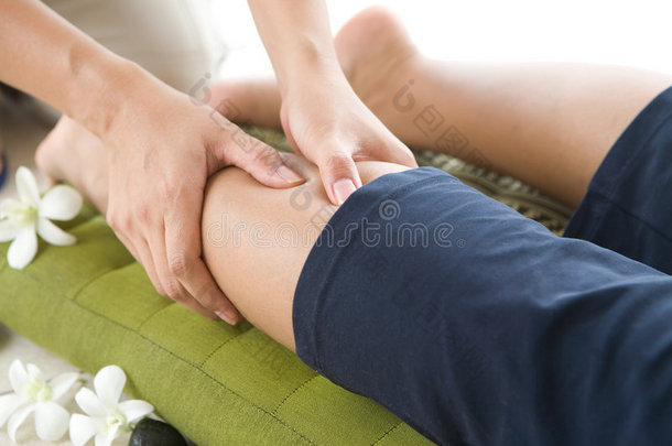 按摩师给女病人做腿部按摩。