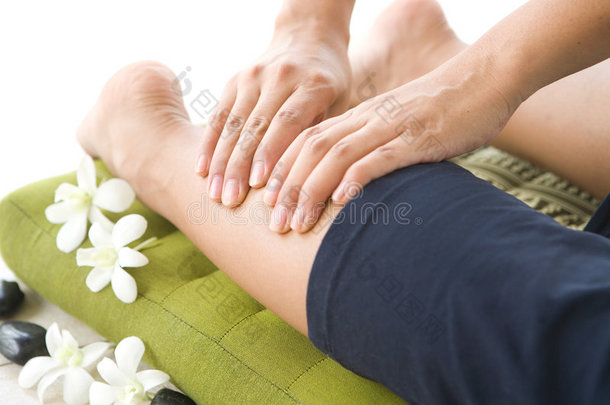 按摩师给女病人做腿部按摩。