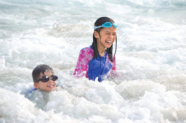女孩和弟弟在海里玩得很开心