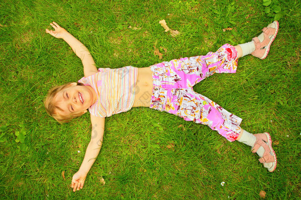 微笑的小女孩仰卧在草地上