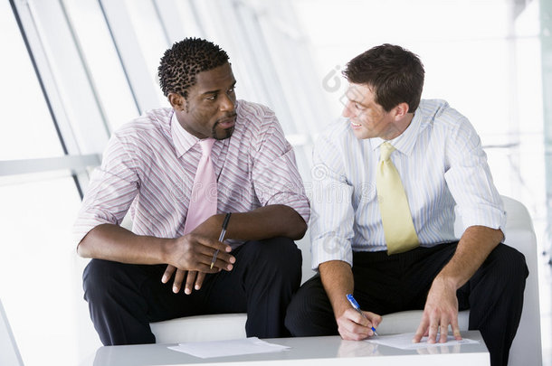 两个商人坐在办公室大厅里<strong>谈话</strong>