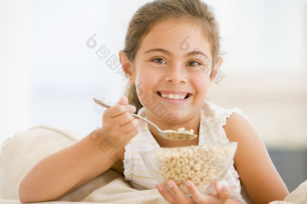 在客厅吃麦片的小女孩微笑着