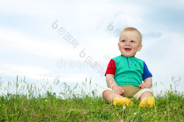 小婴儿坐在绿草上