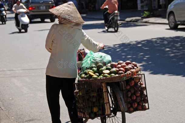 河内一名妇女提着一篮子水果