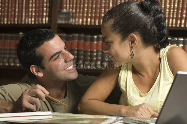 图书馆里的一对情侣相互微笑-水平