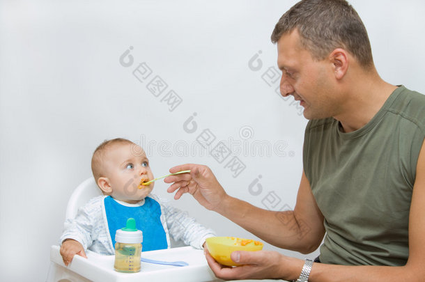 男人用勺子喂婴儿