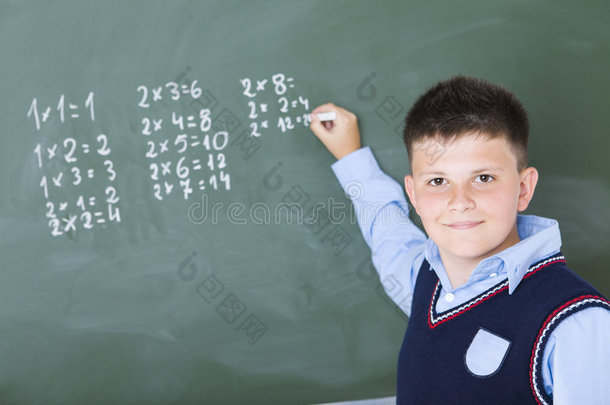 一个男孩在黑板上做乘法