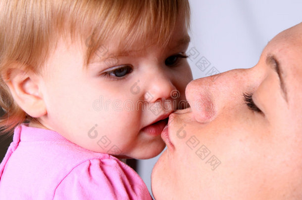 母亲亲吻她的小女儿