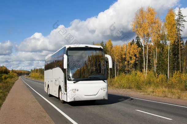 秋季乡村公路上的白色旅游巴士