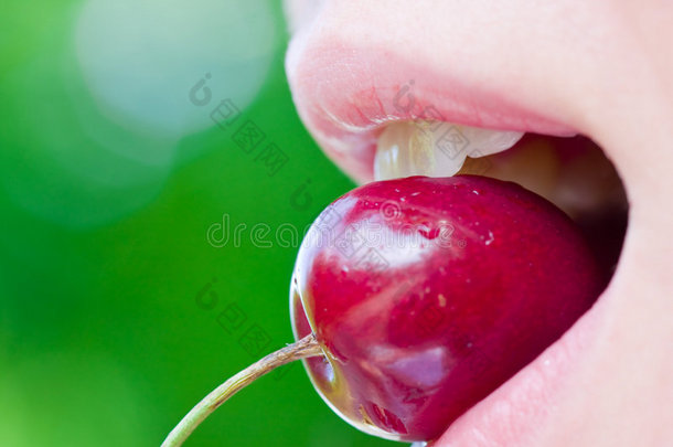 一个女人咬樱桃的特写镜头