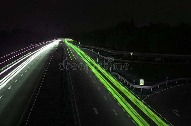 夜间有汽车行驶且灯光模糊的道路