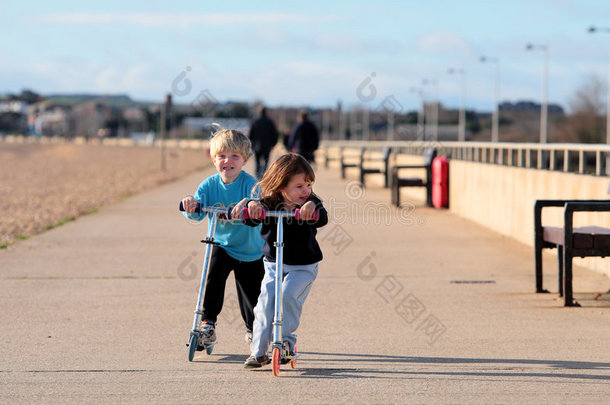 玩滑板车的小男孩和小女孩