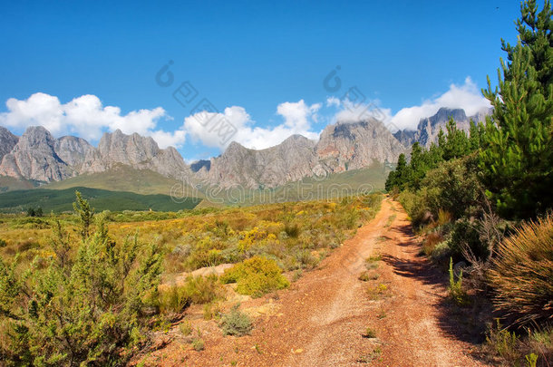 通往巍峨群山的土红色道路