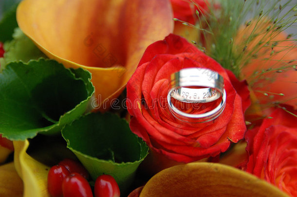 红橙色花朵上的结婚戒指